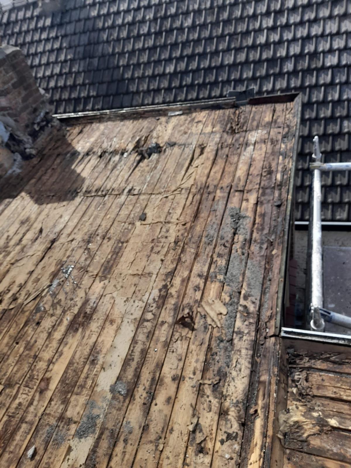Oud houten dakbeschot na het verwijderen van de dakbedekking